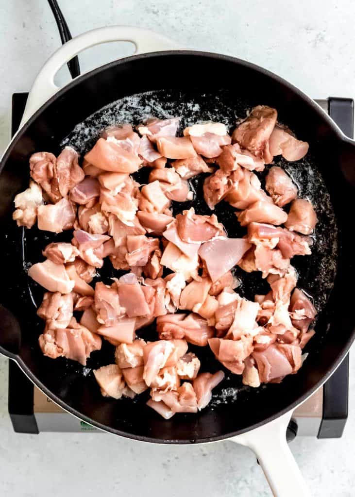 small pieces of chicken thigh in a skillet with butter