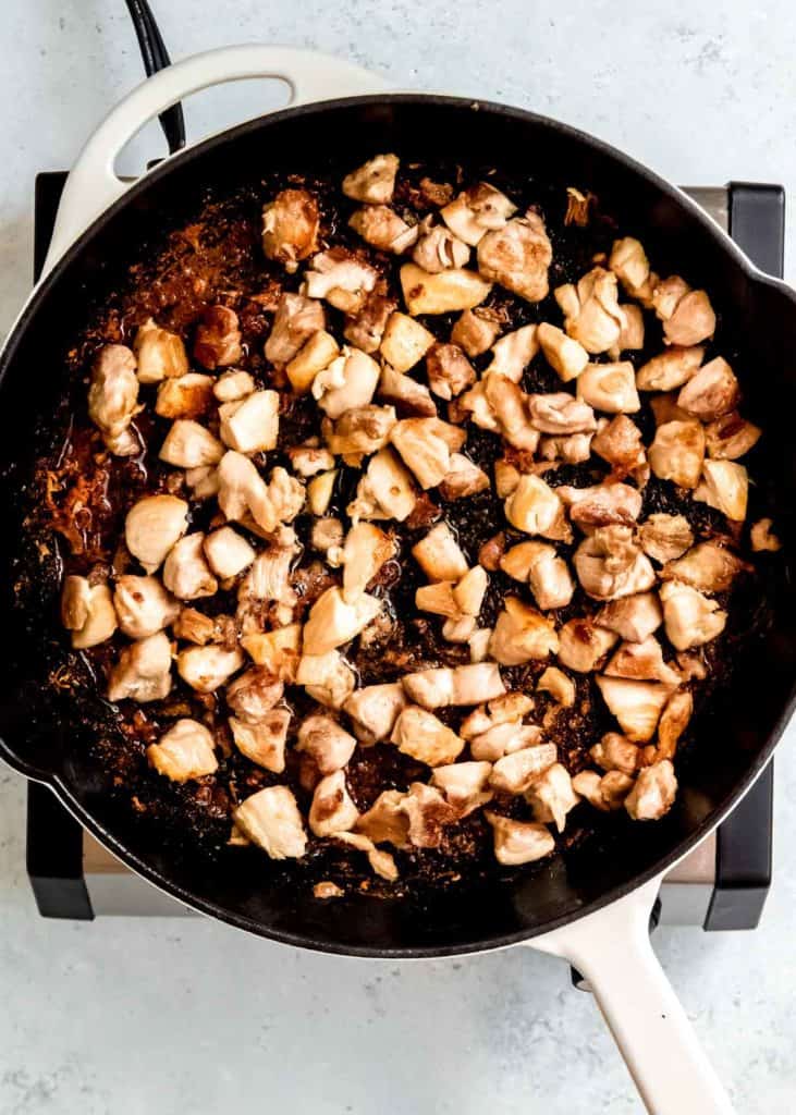 browned chicken thigh pieces in a skillet