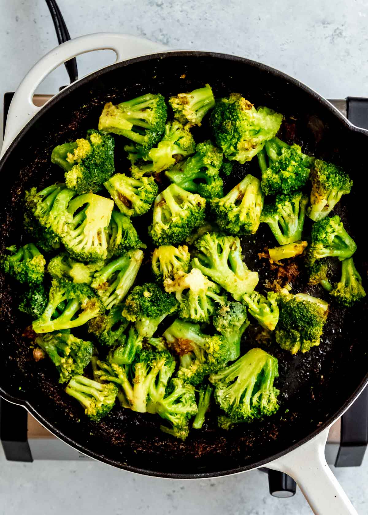 frozen broccoli florets cooking in a skillet