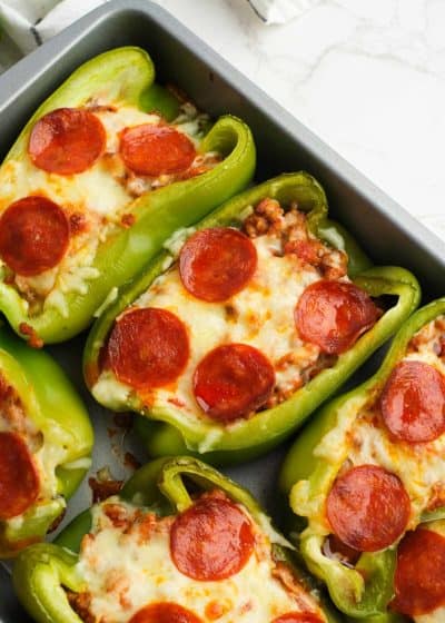 a baking pan filled with pepperoni pizza stuffed bell peppers