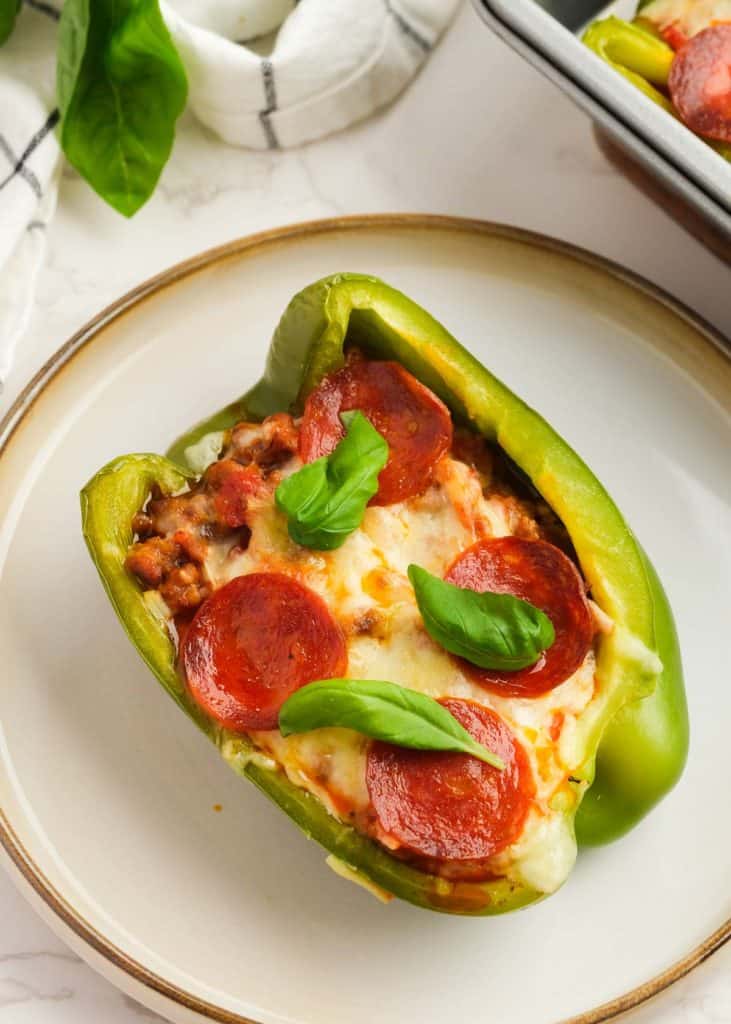 closeup overhead view of keto pizza stuffed peppers garnished with fresh basil
