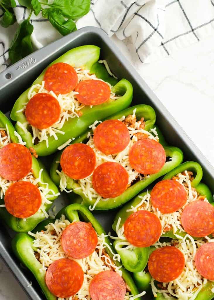 uncooked green peppers filled with sausage, pepperoni, mozzarella, and marinara