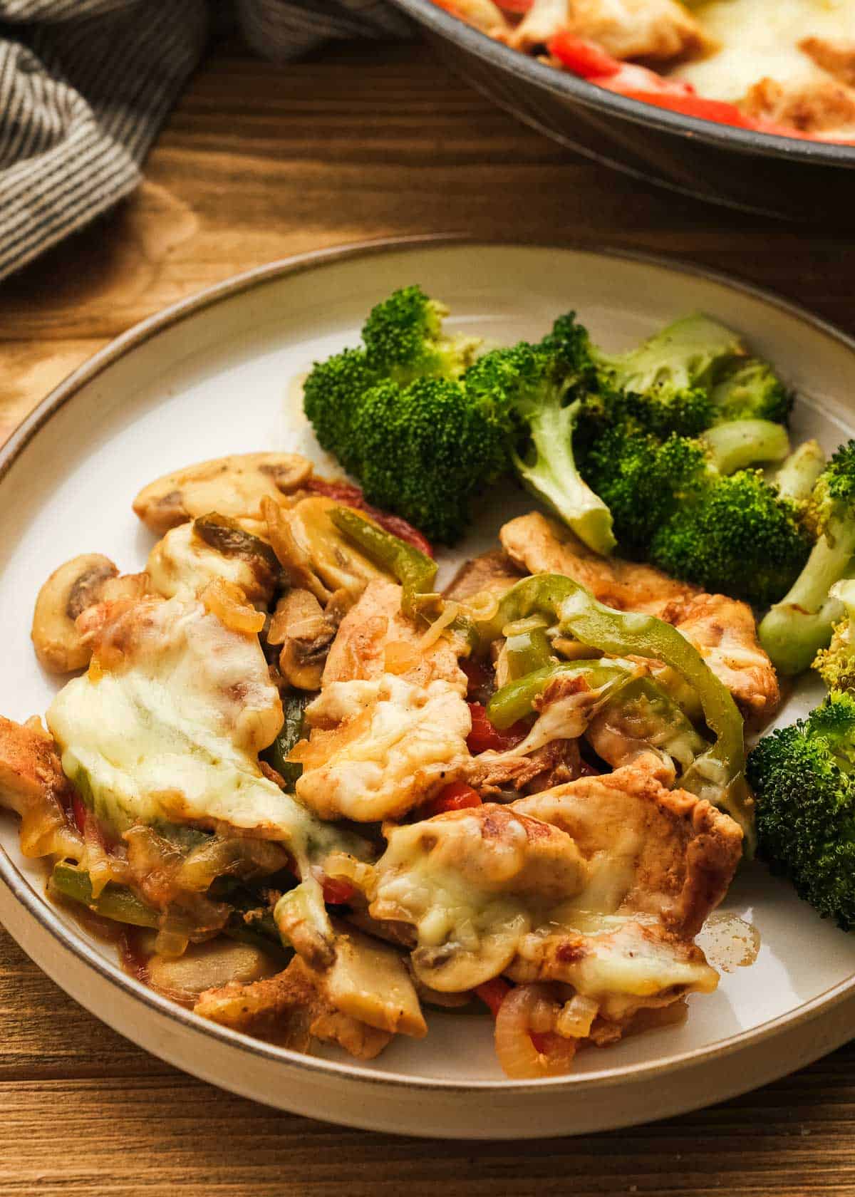 chicken cheesesteak and broccoli on a white plate