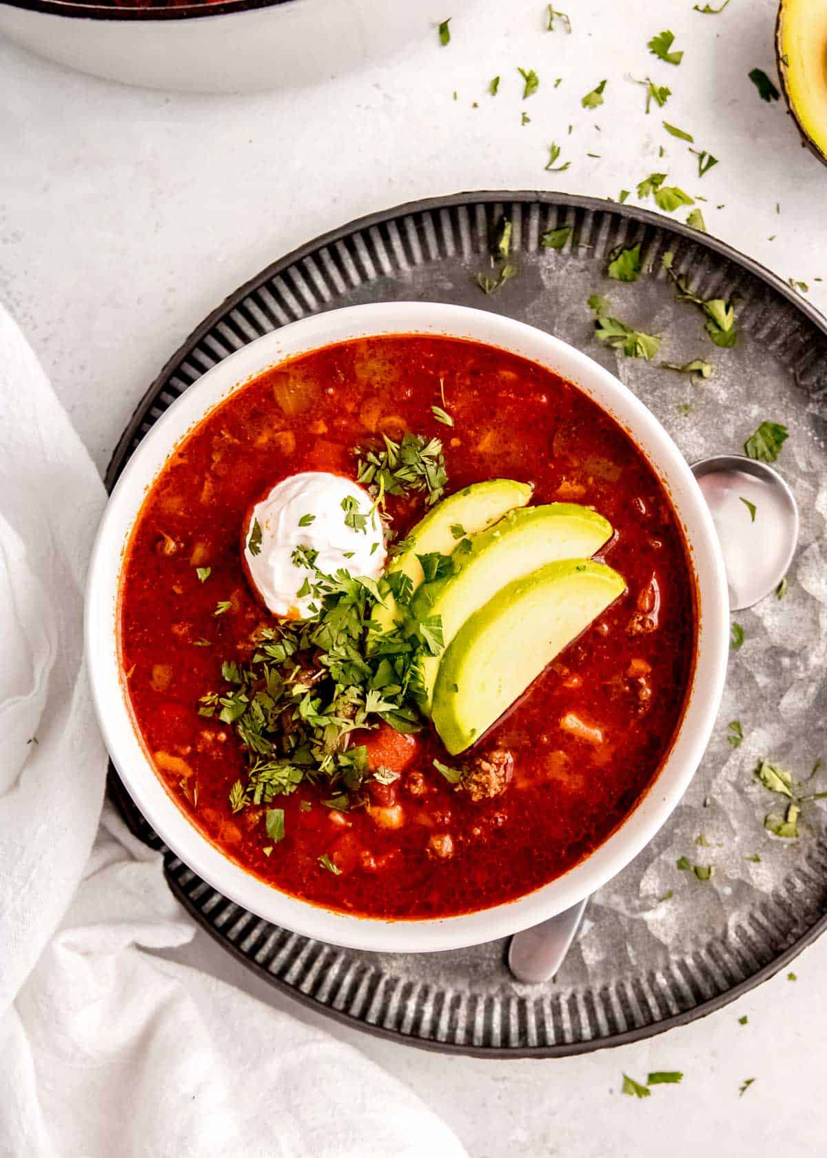 overhead image of taco soup in white bowl on silver platter