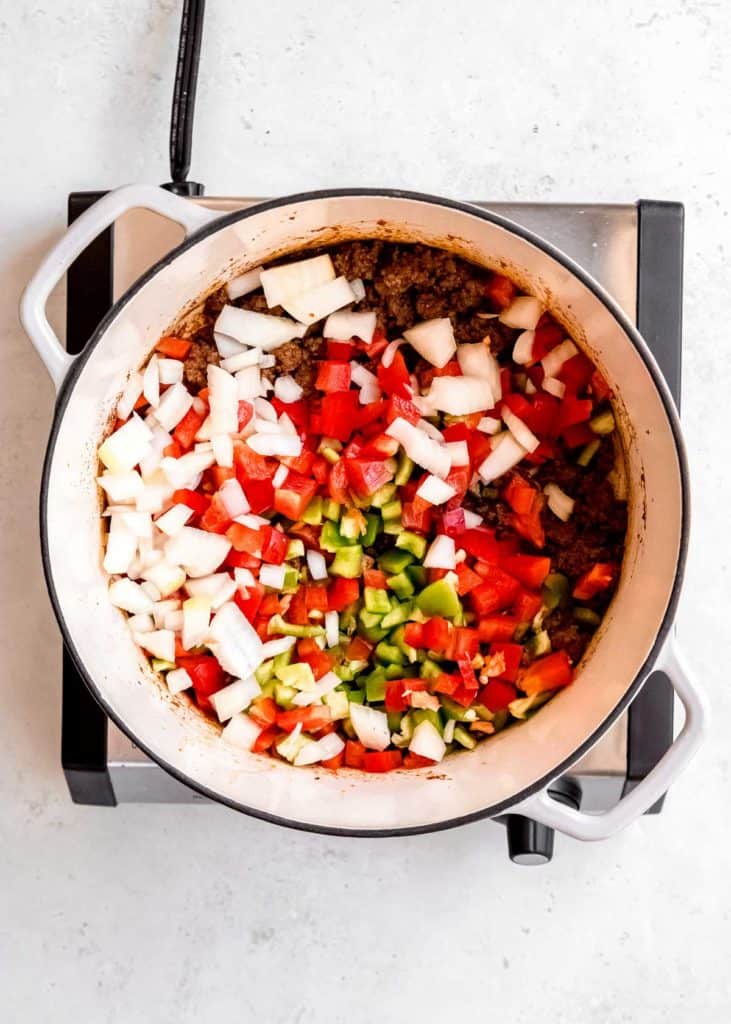 vegetables being added to taco soup in dutch oven