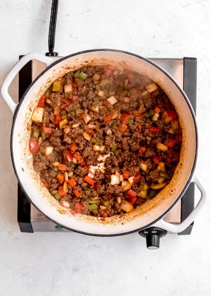 vegetables being sauteed with ground beef in dutch oven