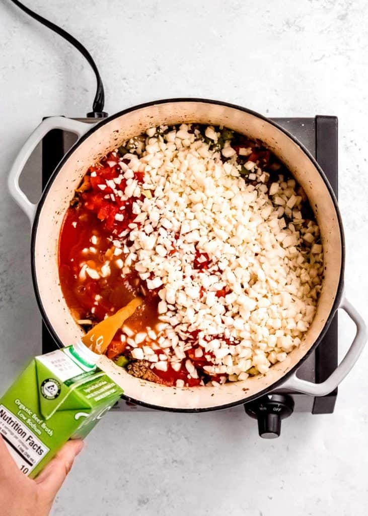 overhead image of broth being added to dutch oven