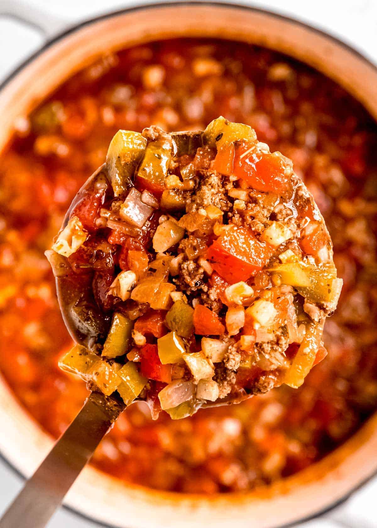 close up image of spoonful of soup with bowl of soup in background