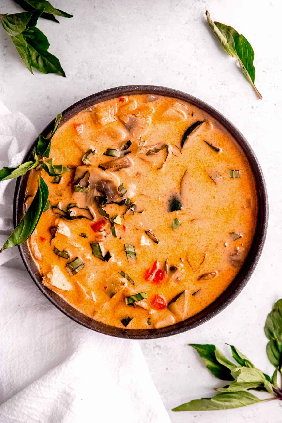 overhead image of thai curry chicken soup in black bowl