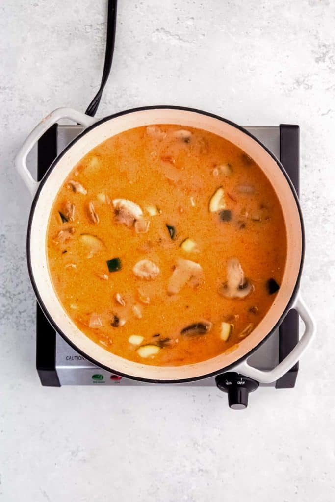 overhead image of thai curry chicken soup while simmering