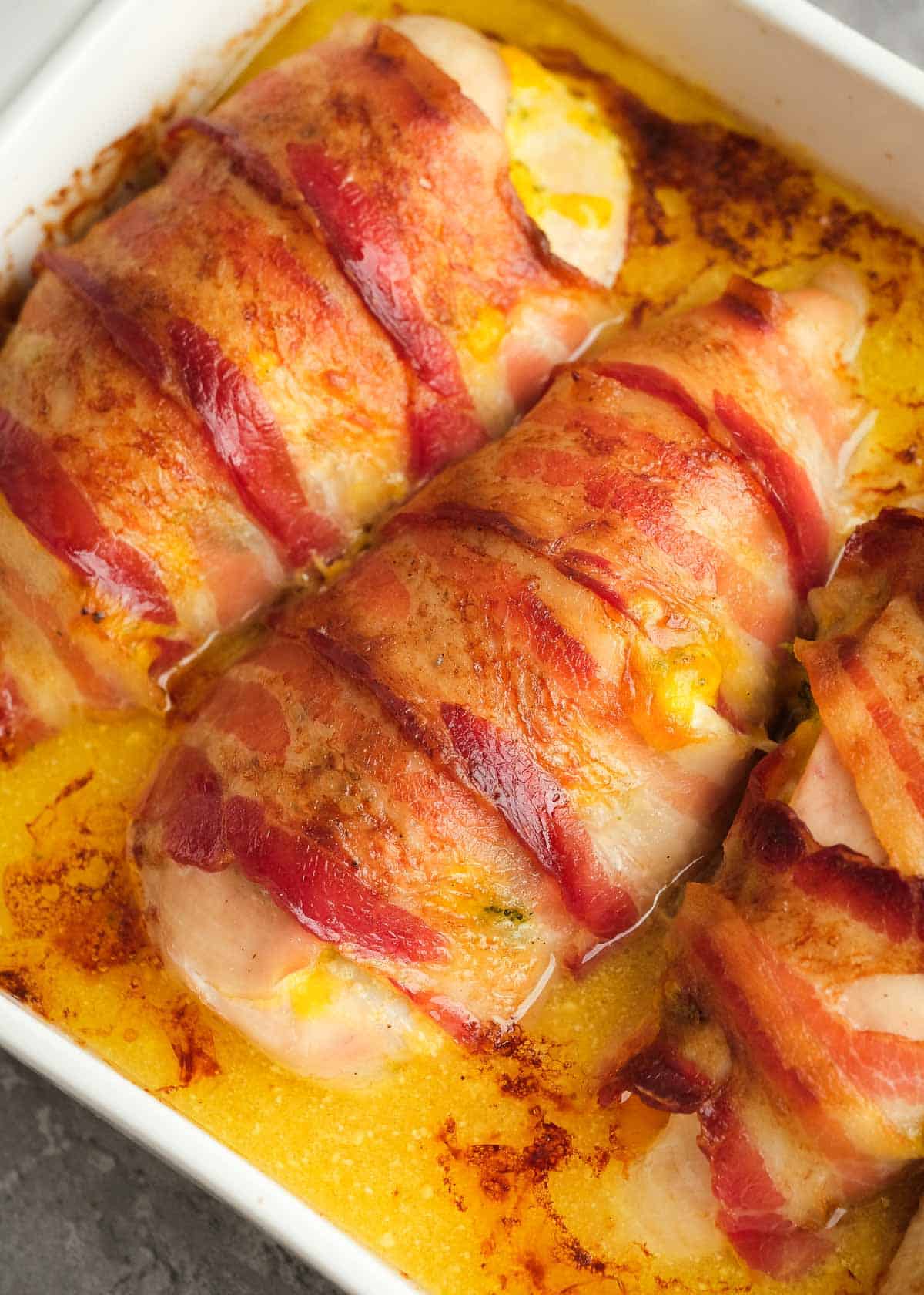 close up image of cooked bacon wrapped stuffed chicken breasts 