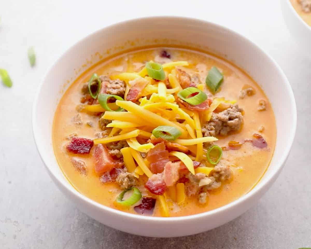 overhead image of garnished cheeseburger soup in white bowl