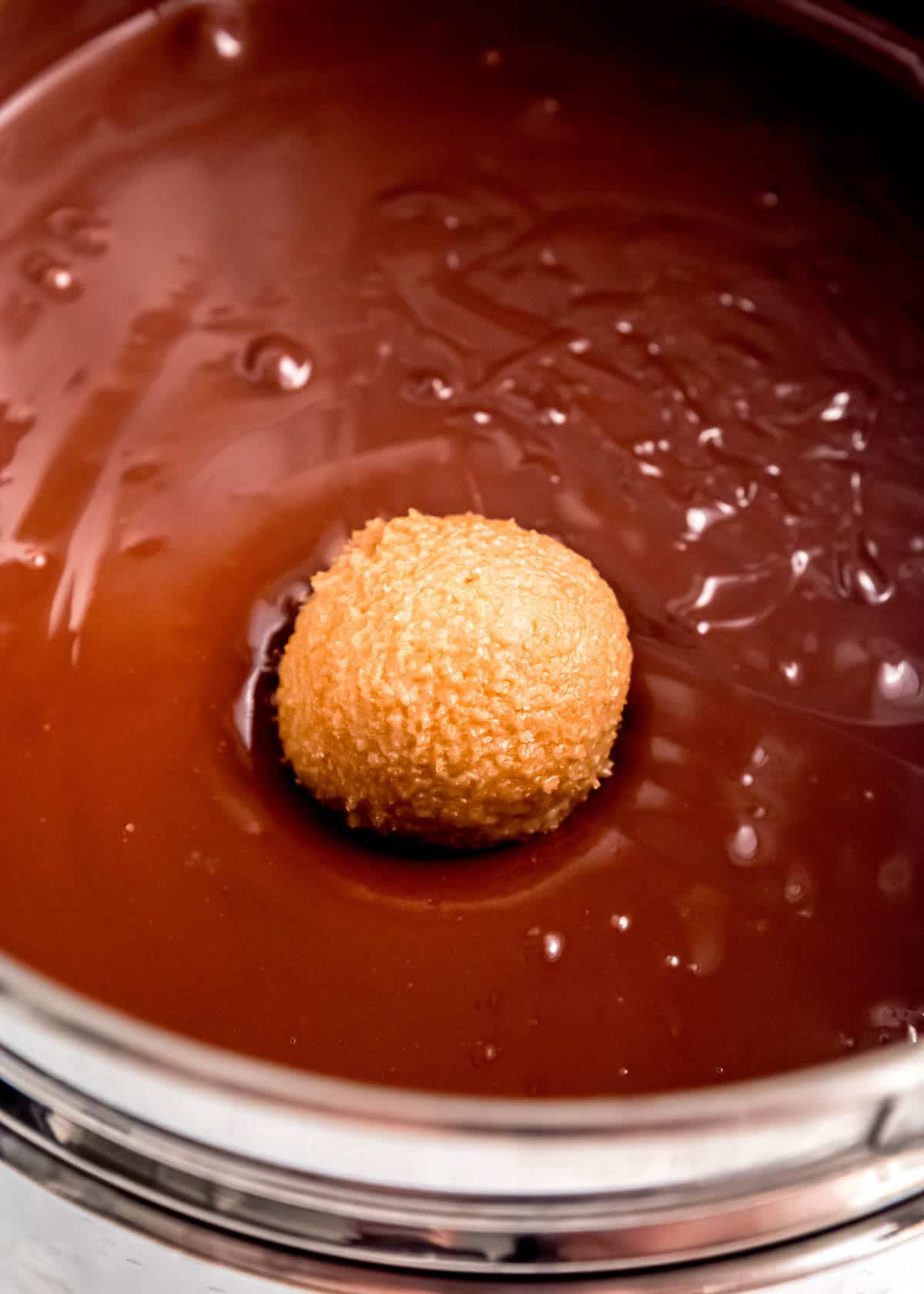 truffle filling being dipped in chocolate coating