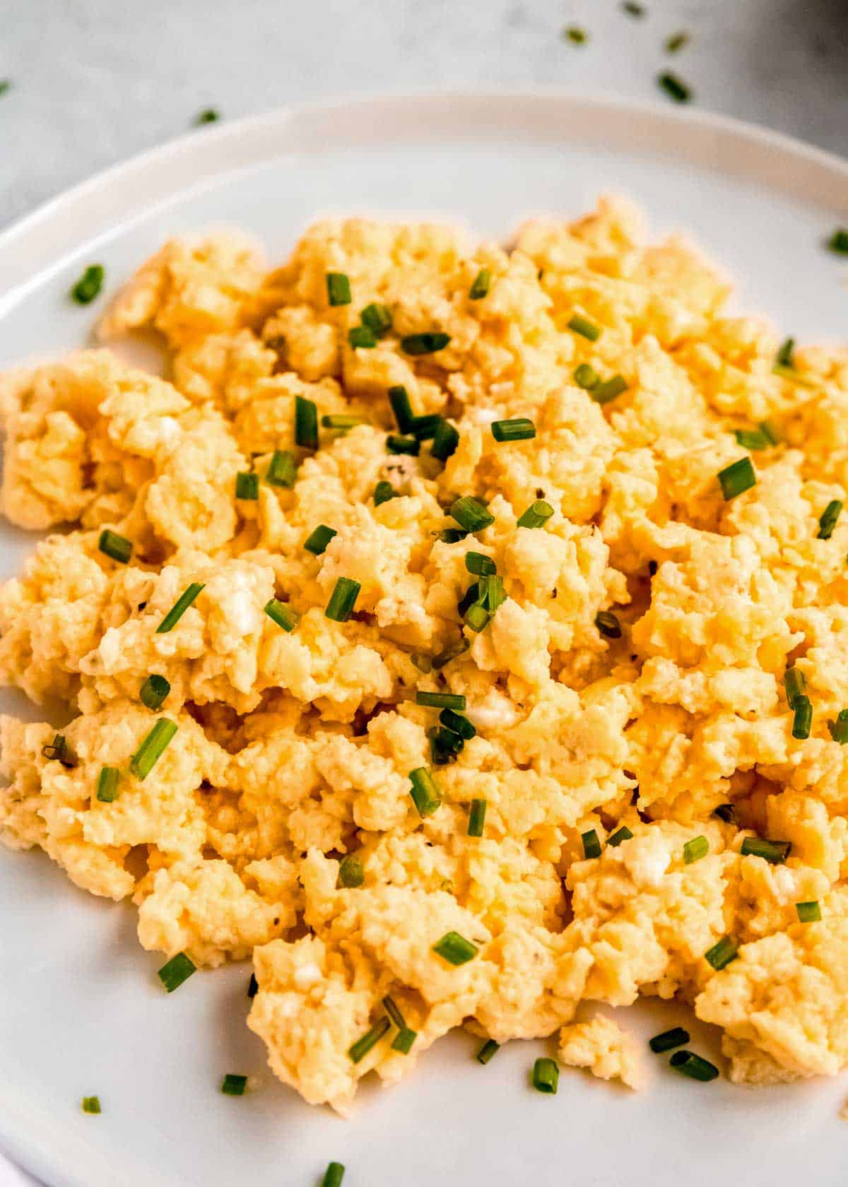 a close up of scrambled eggs on a white plate