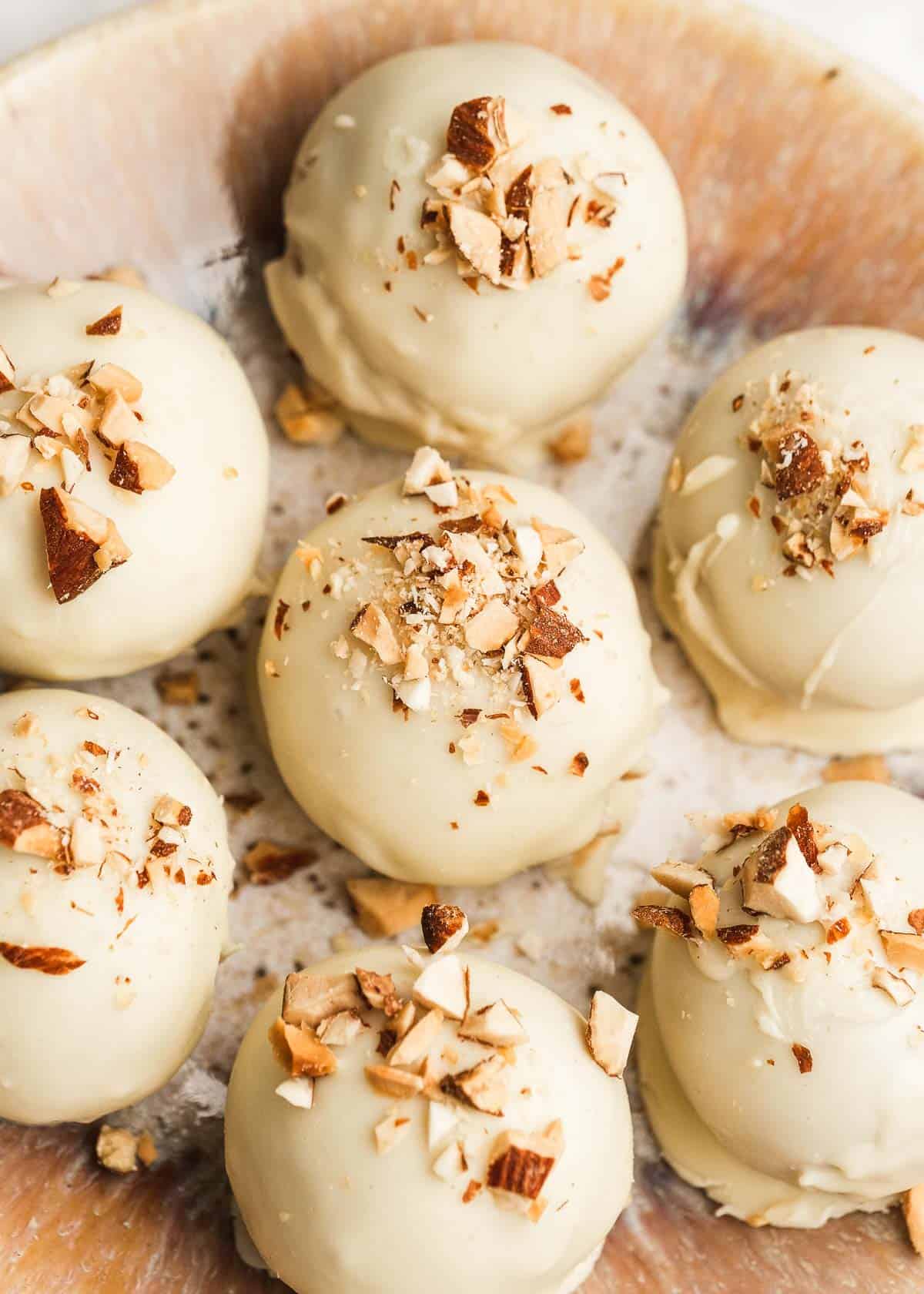 close up of several almond butter truffles on a white table 