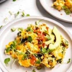 overhead image of California scramble on white plate with white table and another plate in background