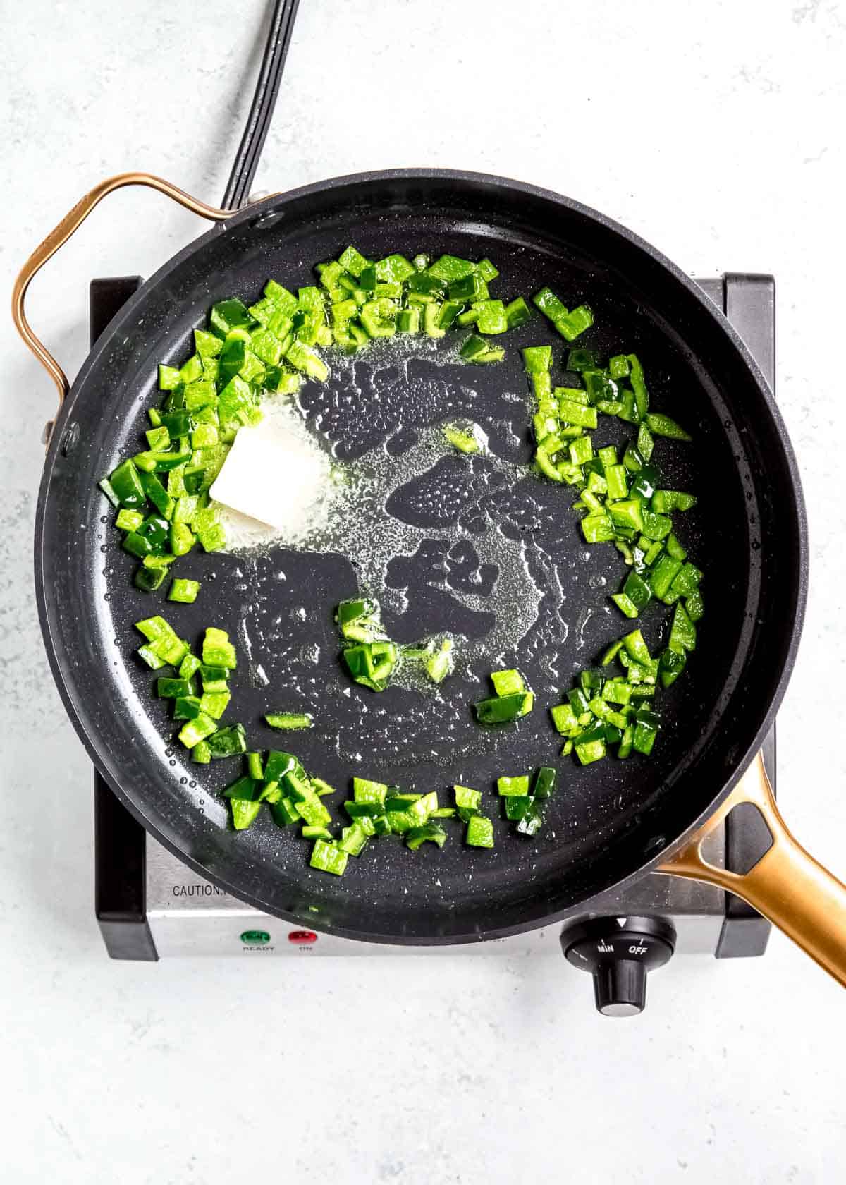 diced pepper and butter in a black skillet