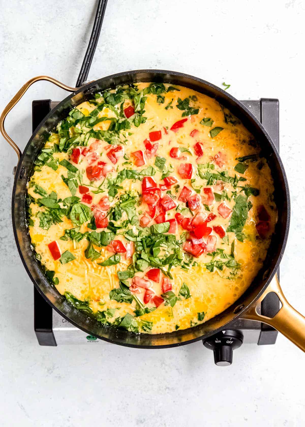 eggs and veggies in black skillet