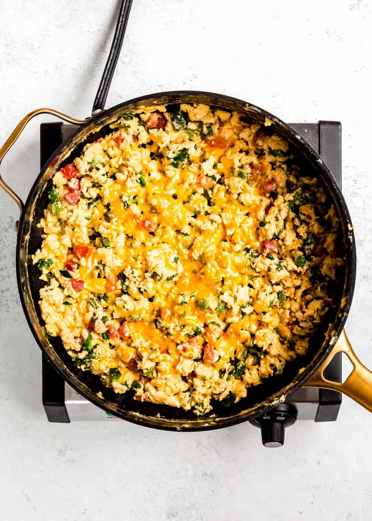 California scramble in a black skillet after adding cheese