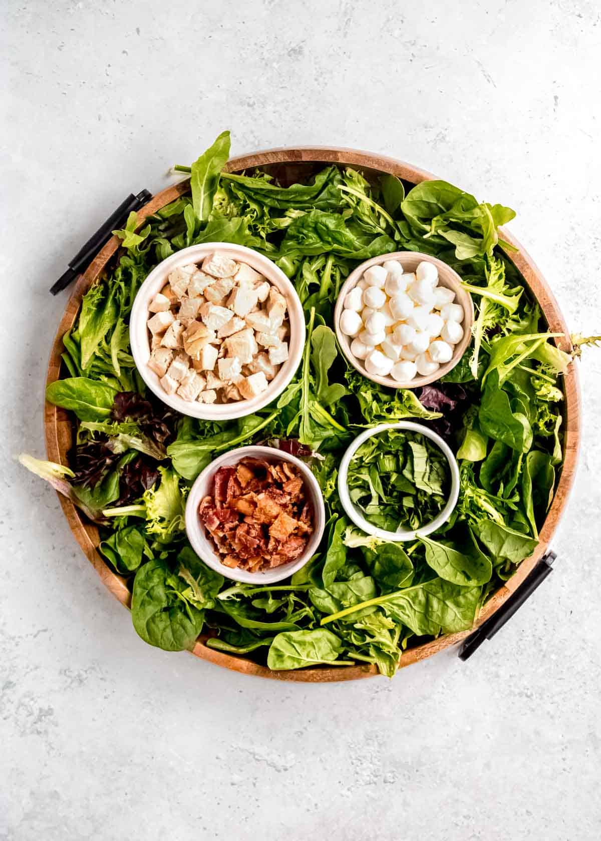 overhead image of caprese salad board after adding greens