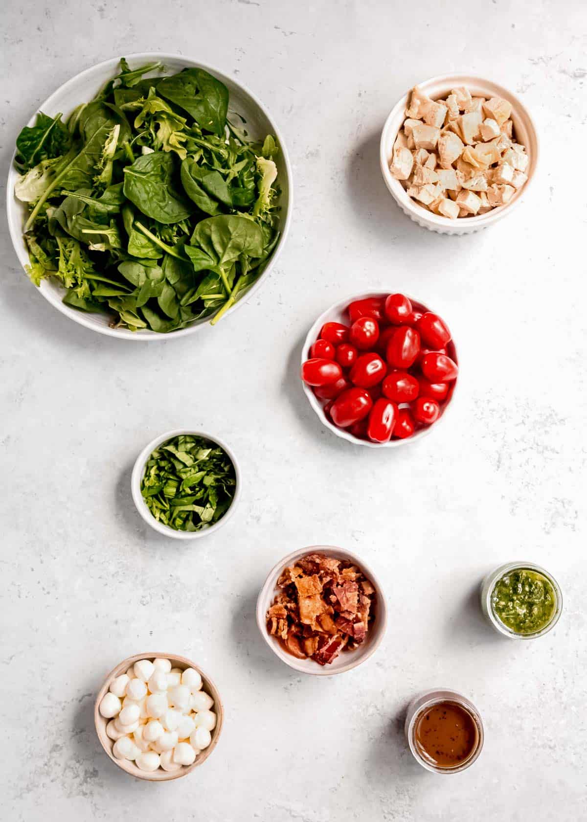 overhead image of caprese salad ingredients on a white table