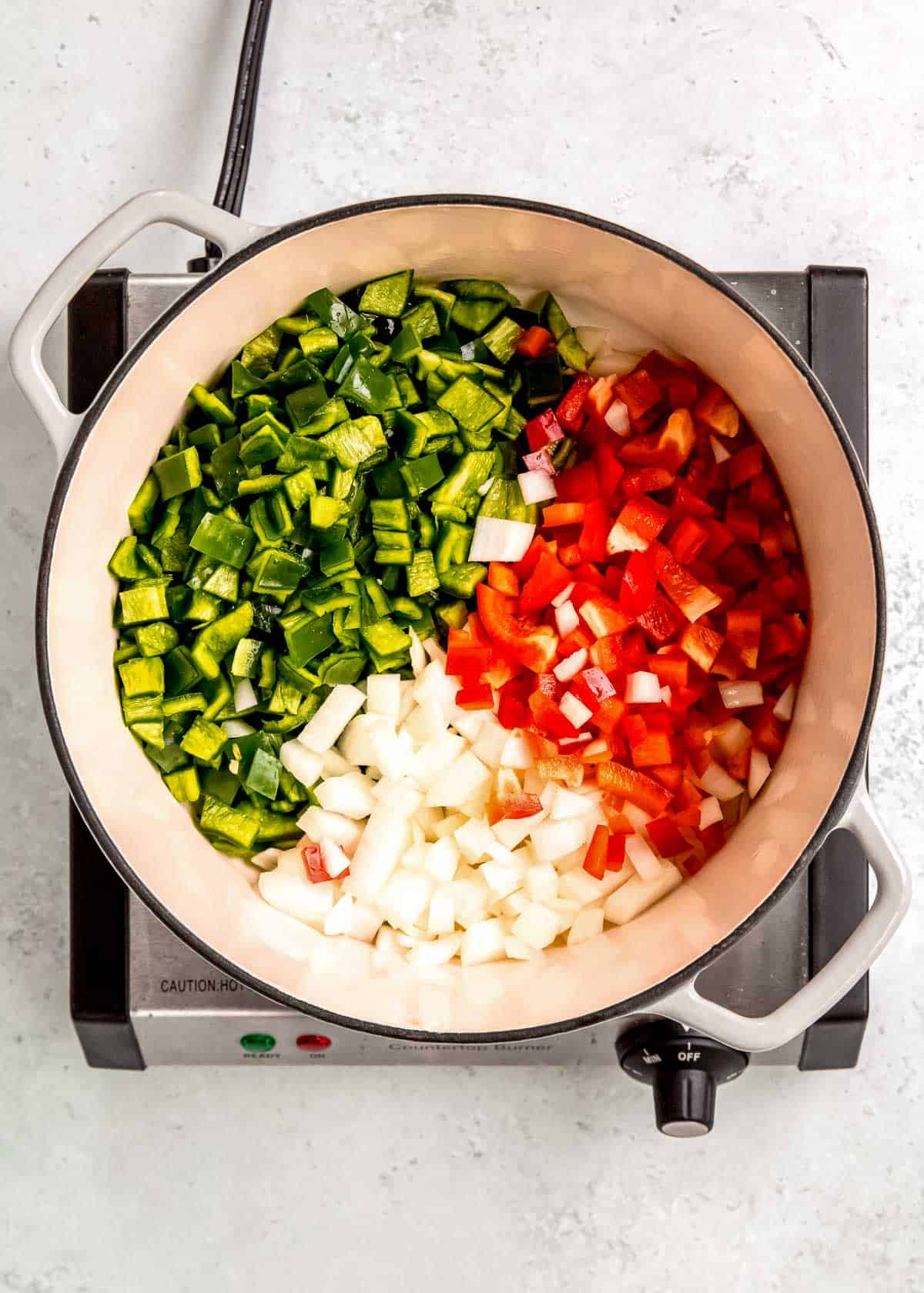 overhead image of bell pepper and onion in dutch oven