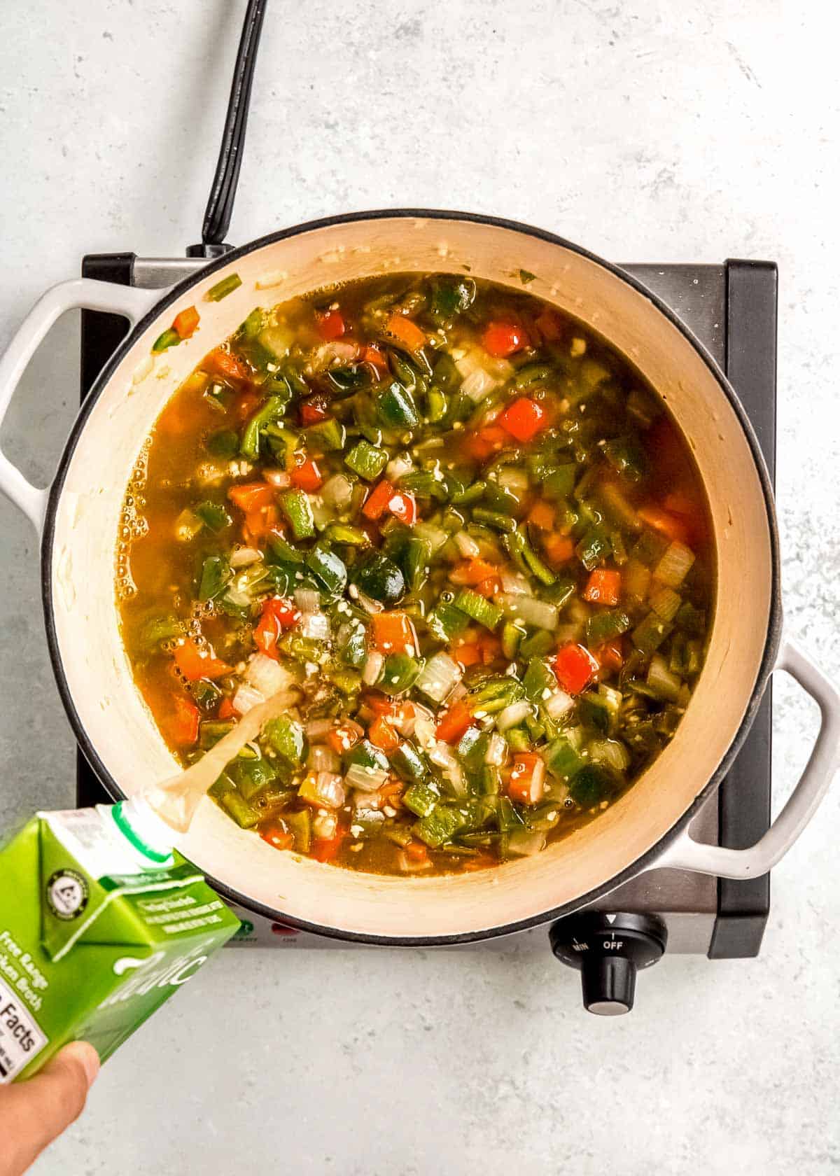 chicken broth being added to chile relleno soup