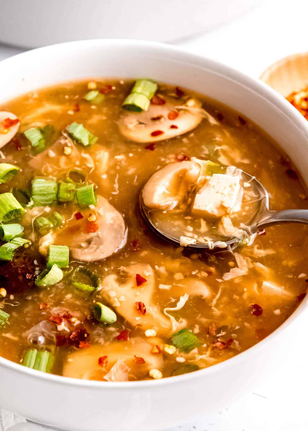 close up image of hot and sour soup in a white bowl