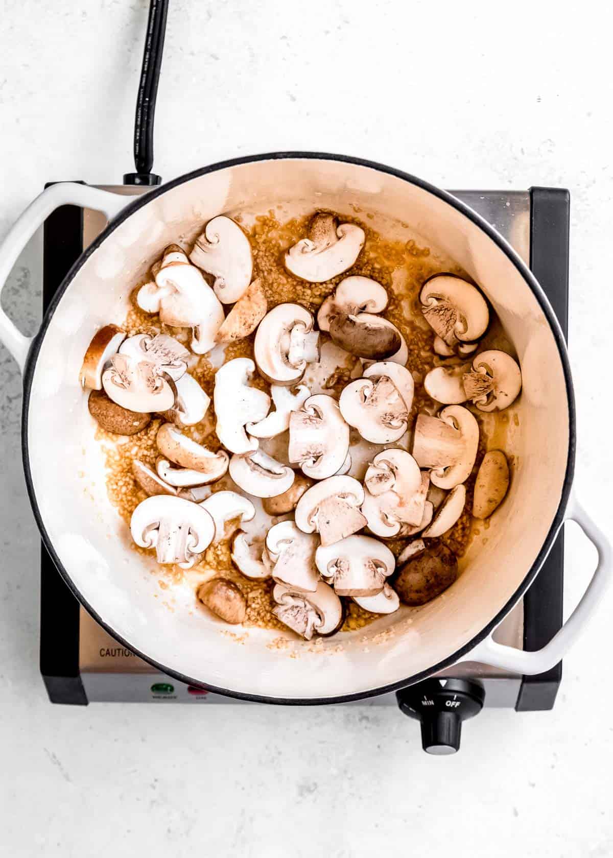 mushrooms being sauteed in dutch oven