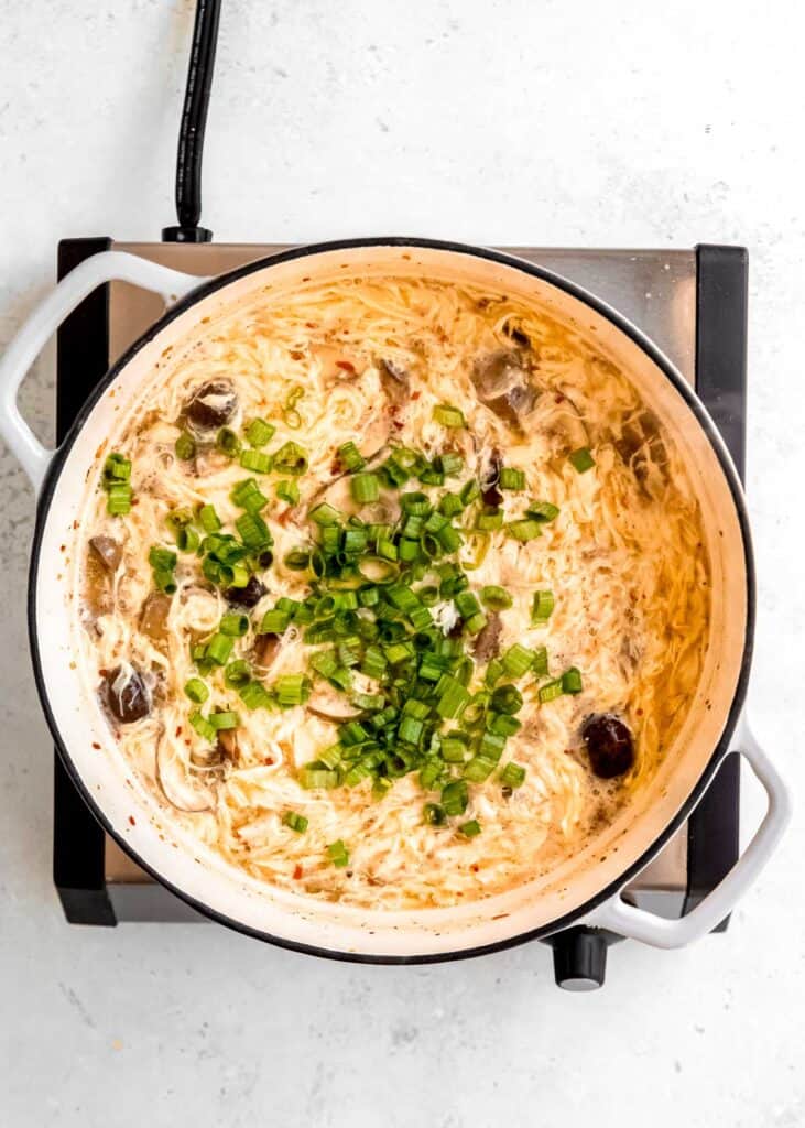 hot and sour soup being stirred in dutch oven