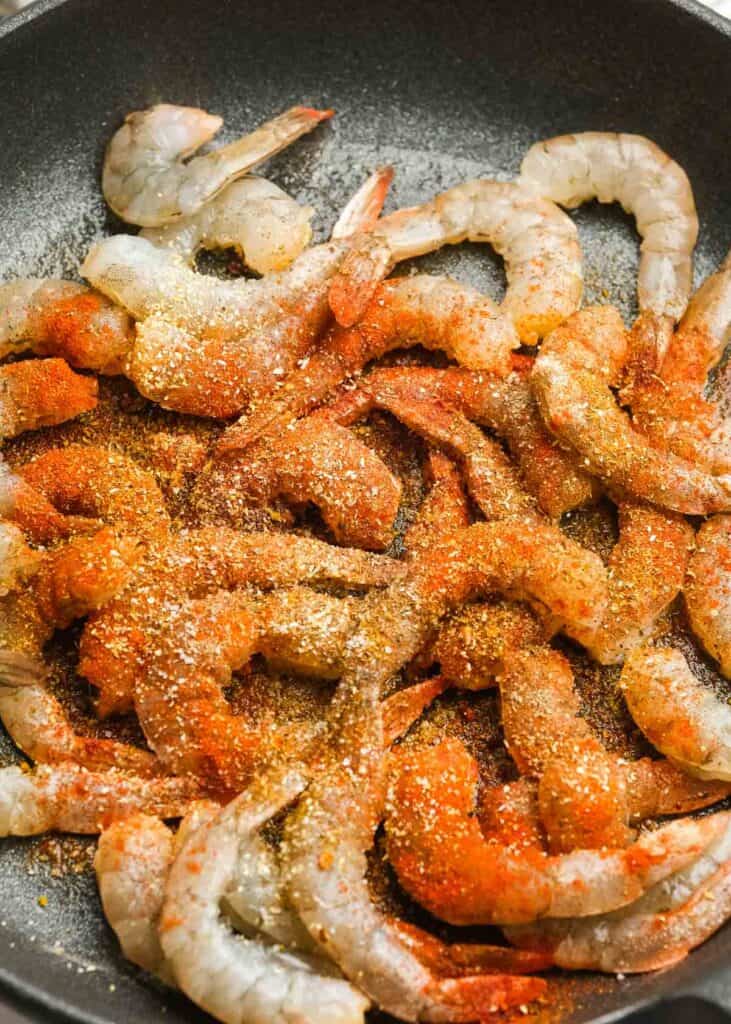 raw, seasoned shrimp in cast iron skillet