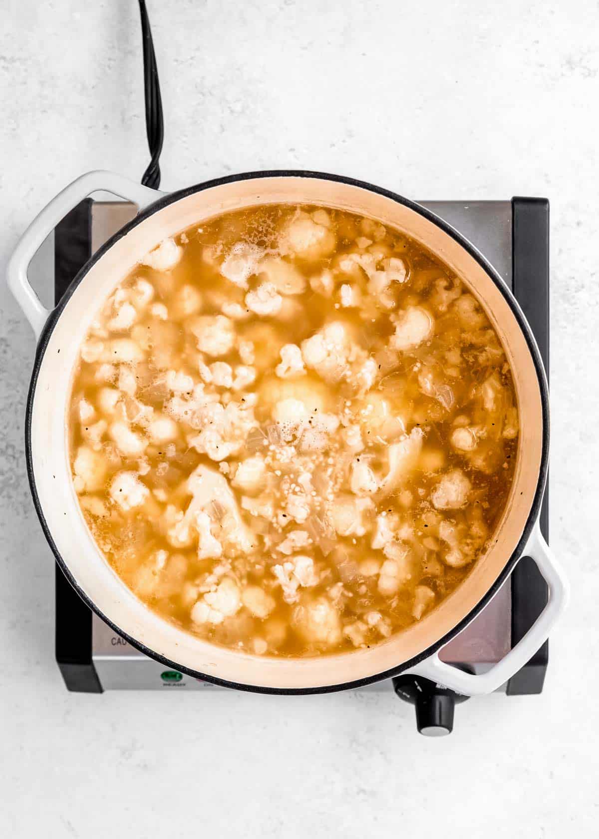 loaded cauliflower soup simmering in dutch oven