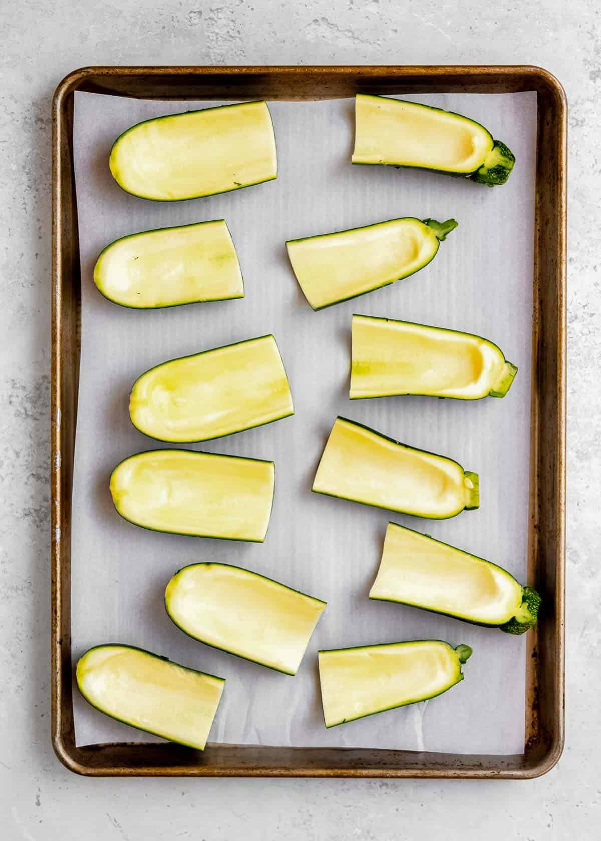 hollowed out zucchinis on a sheet pan