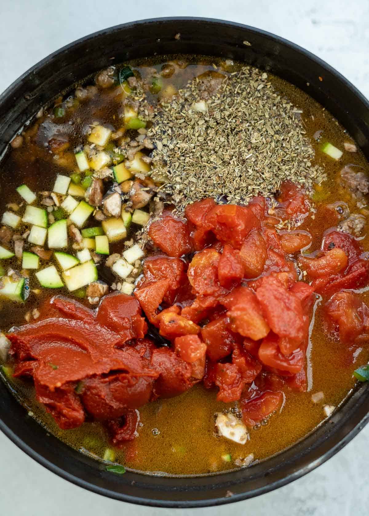 beef broth being added pizza soup