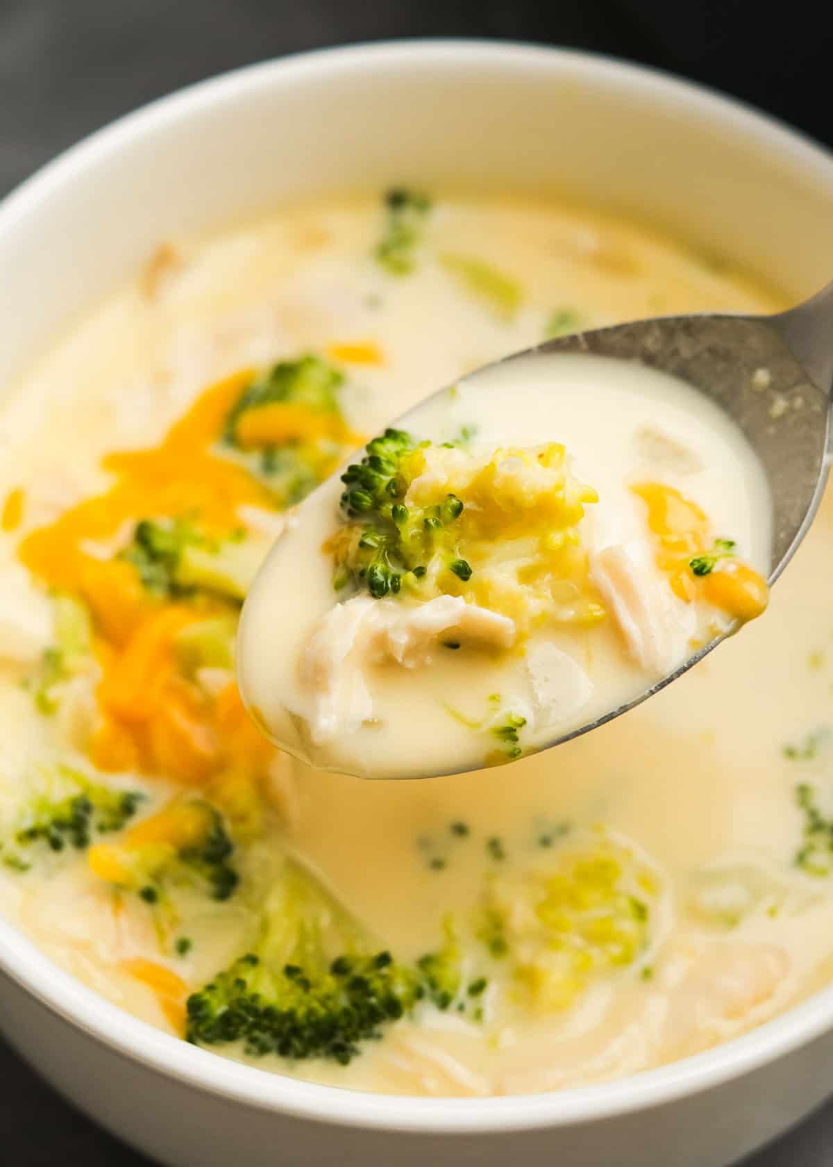 close up, overhead image of a spoonful of broccoli cheese soup after garnishing