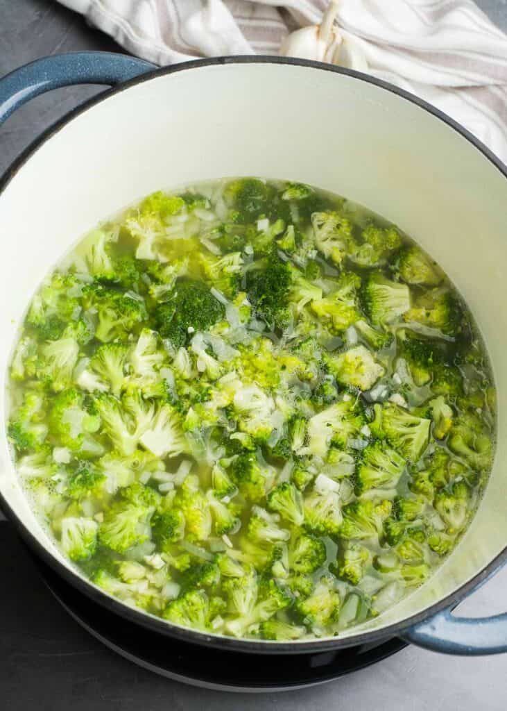 broccoli being added to dutch oven