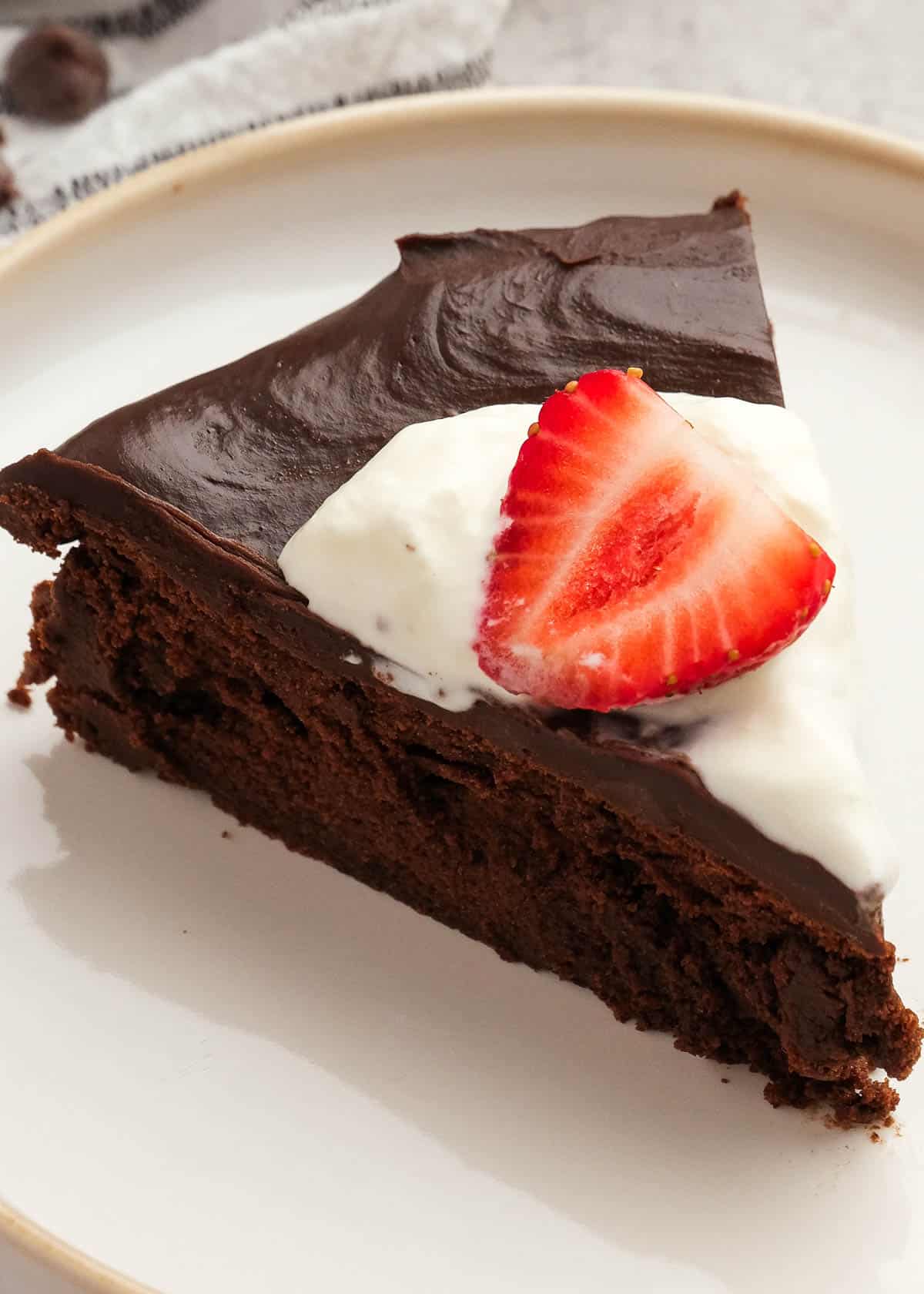 close up image of one slice of death by chocolate cake on a white plate