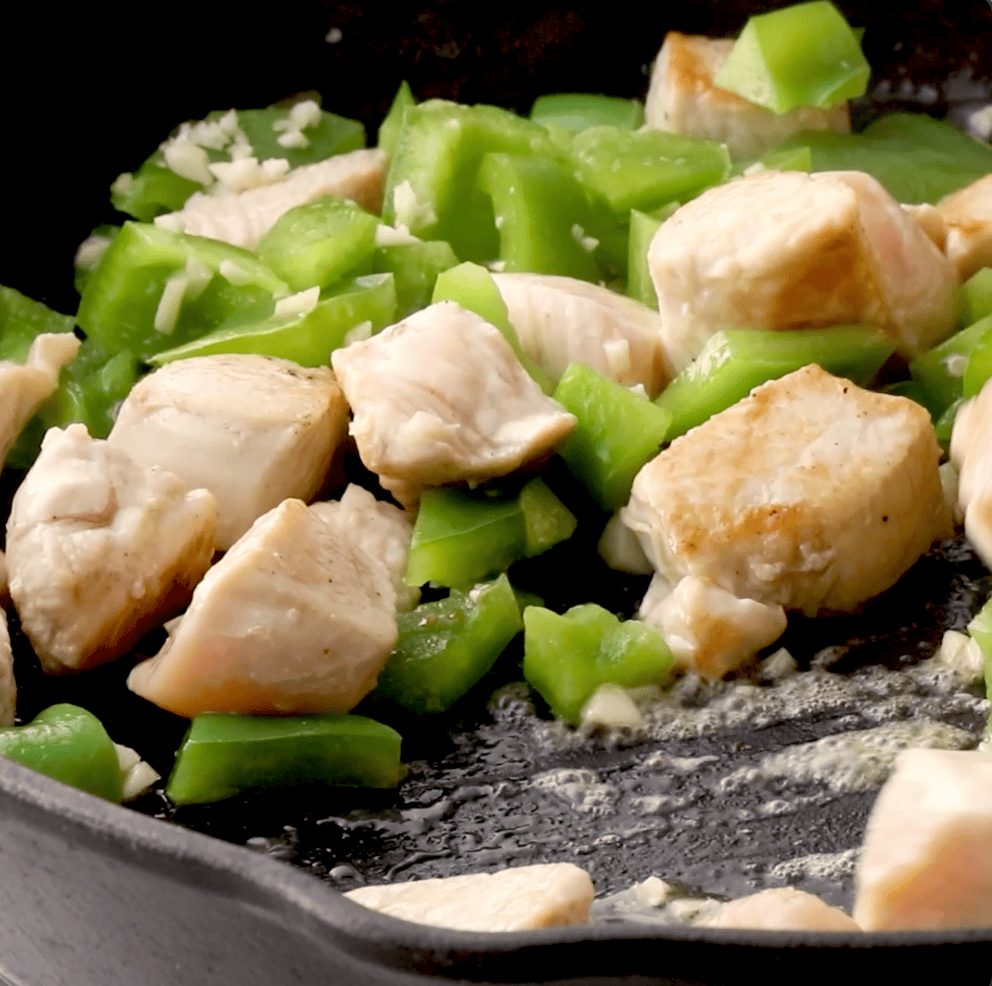 chicken and bell pepper cooking in skillet