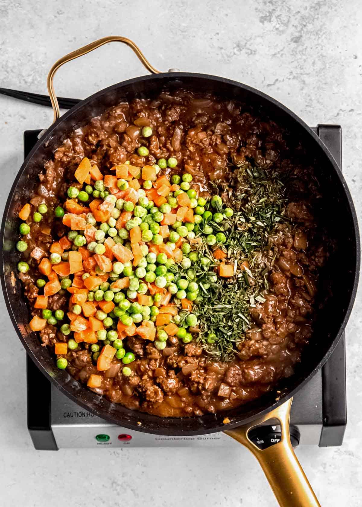 ground beef and vegetables in a cast iron skillet