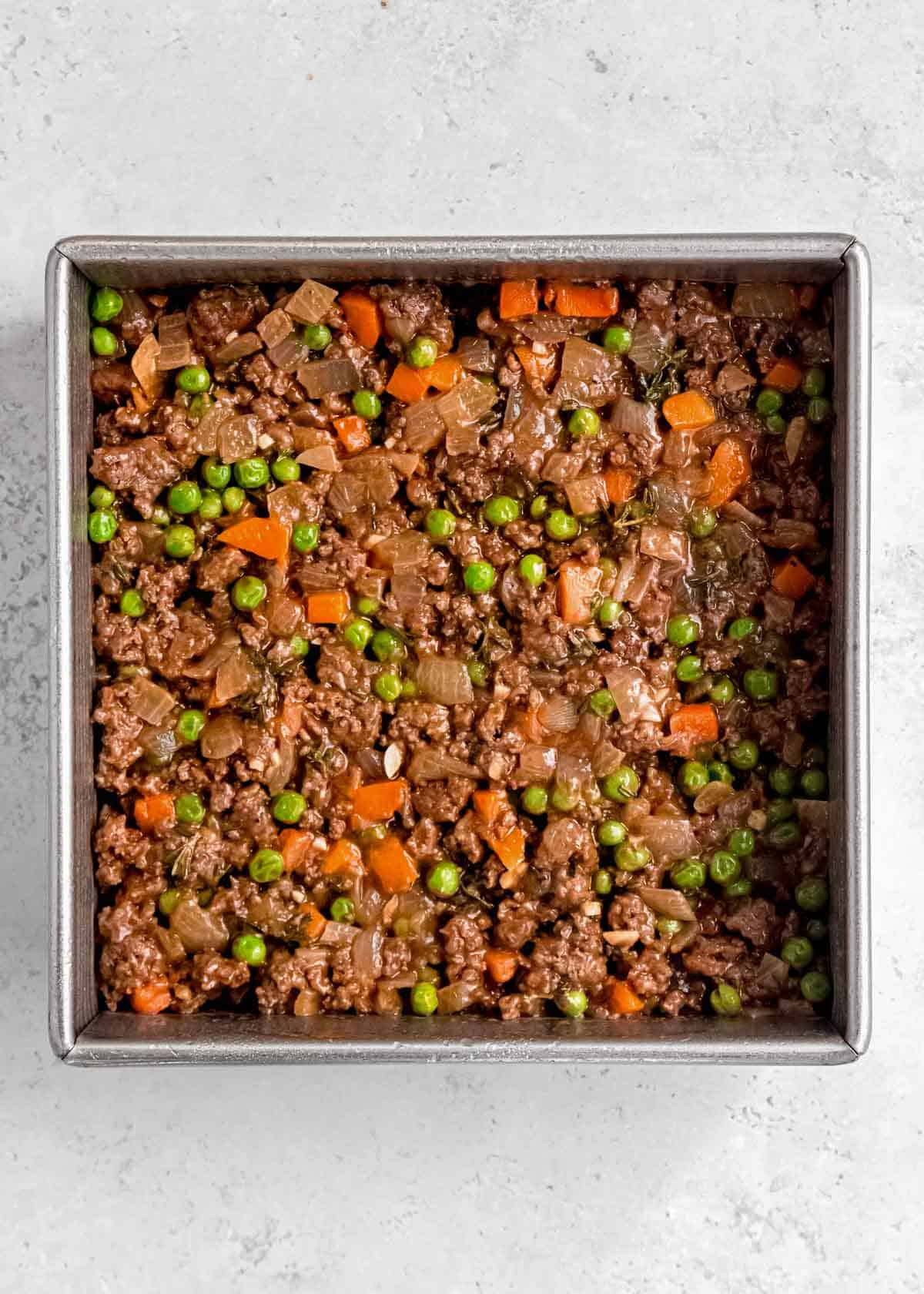shepherd's pie filling being added to pan