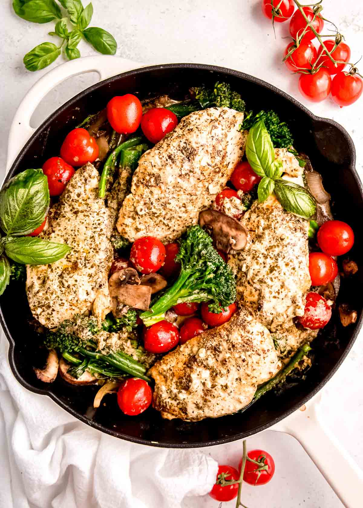 overhead image of basil being added to pesto chicken skillet