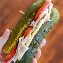 a dill pickle filled with deli meat, cheese and vegetables