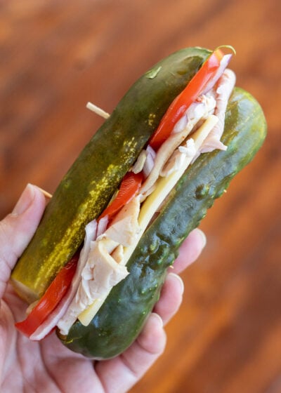 a dill pickle filled with deli meat, cheese and vegetables