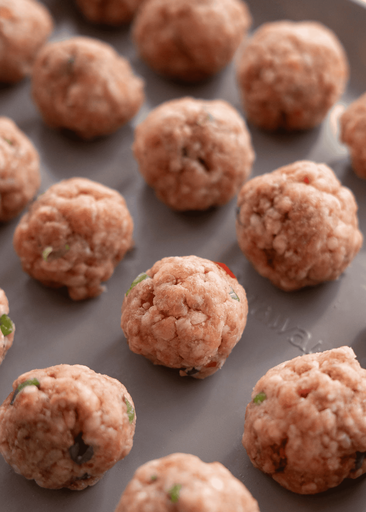 rolled meatballs on a baking sheet uncooked