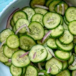 overhead image of cucumber dill salad in white bowl