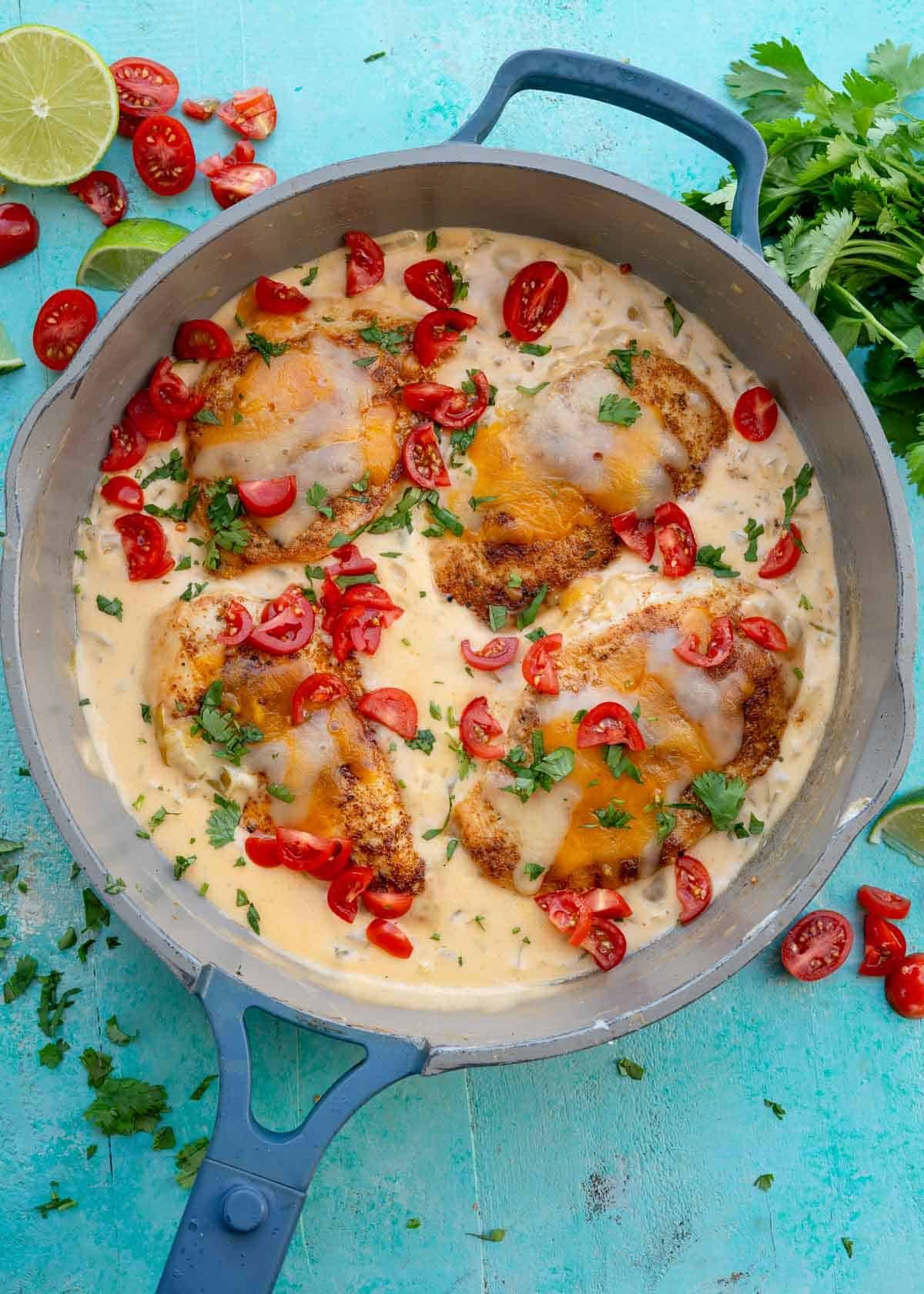 overhead shot showing a skillet filled with four green chili chicken breasts in a creamy sauce