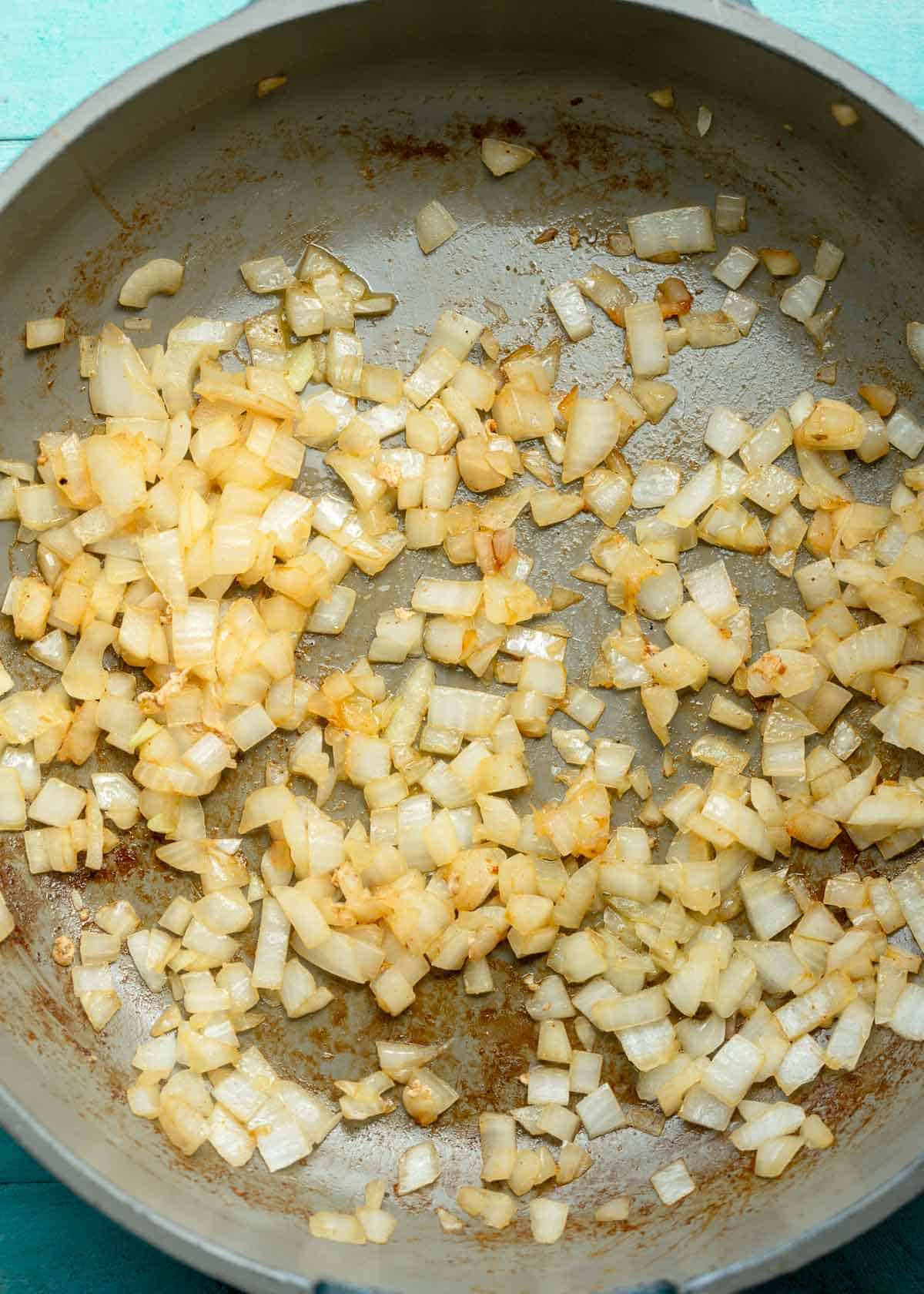 diced onions sauteing in a skillet