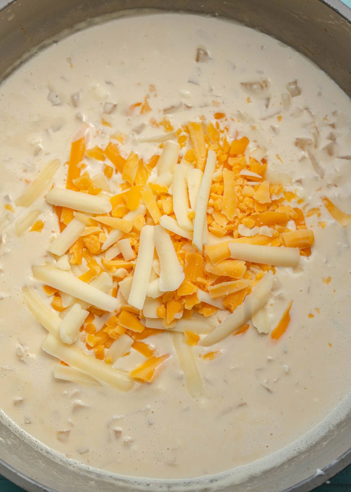 a creamy sauce with shredded cheese in a skillet