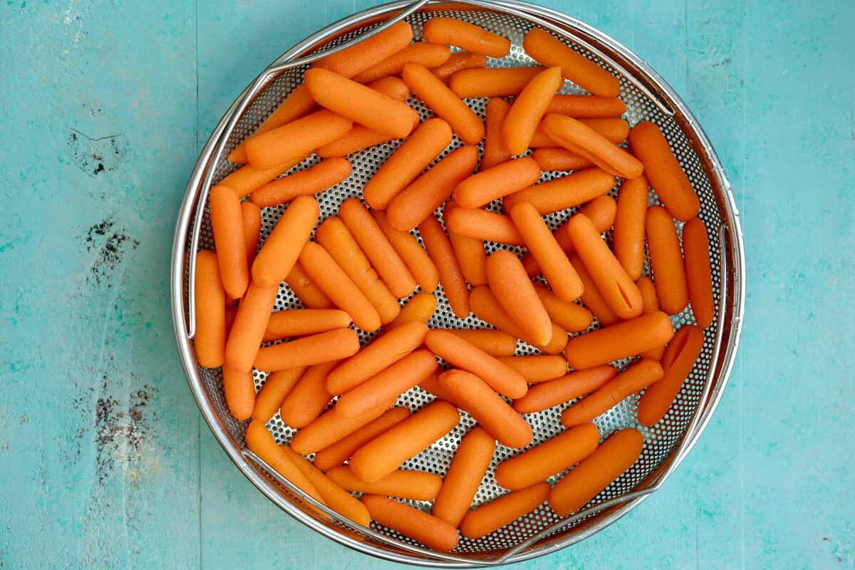 steamed carrots in a steamer basket
