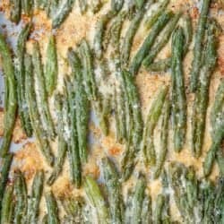 overhead image of smashed green beans with crispy cheese on baking sheet